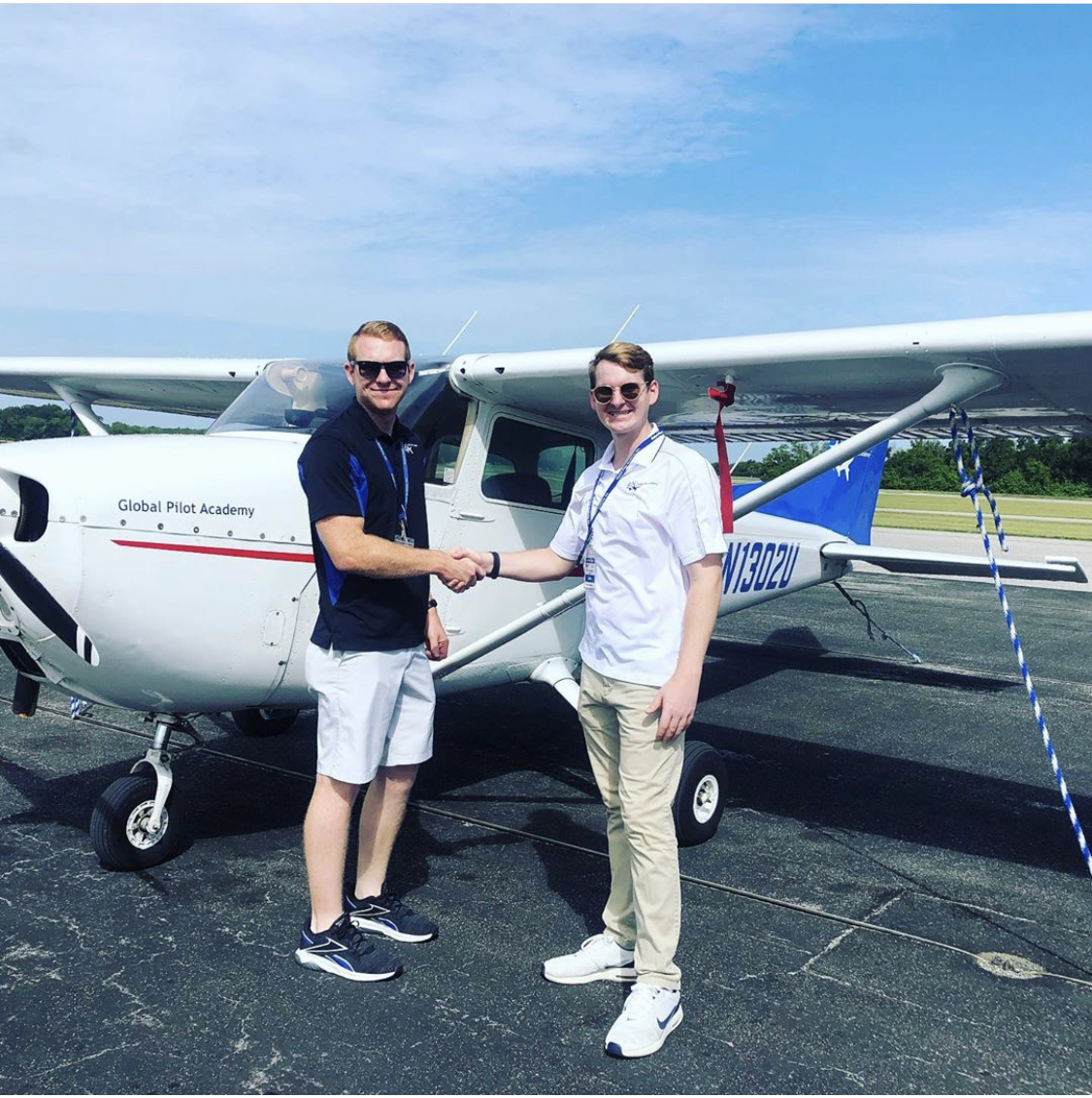Student milestone handshake in front of GPA Cessna